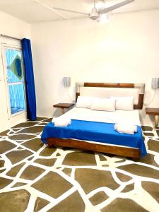 瓦塔穆Luwa Beach&Suits的卧室配有1张床,铺有地毯。