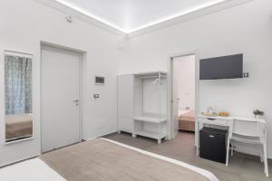 巴勒莫MolteVolte Rooms的白色的客房配有书桌和床。