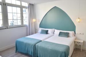 维戈Hotel Alda Puerta Del Sol的一间卧室设有两张床和两个窗户。
