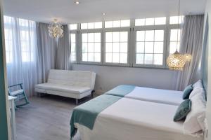 维戈Hotel Alda Puerta Del Sol的一间卧室配有一张床、一把椅子和窗户。
