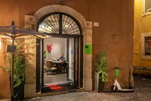 罗马纳沃纳色彩酒店的坐在一张桌子上的男人坐在一个敞开的门道上