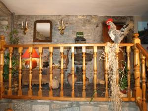 Sieste卡萨皮克罗乡村民宿的一只公鸡坐在木栏杆上