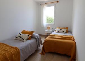卡拉布兰卡Apartamento Tramuntana 3的白色客房的两张床,设有窗户