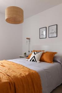 卡拉布兰卡Apartamento Tramuntana 3的一间卧室配有一张带橙色毯子的床