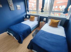 伦敦2 BEDROOM FLAT NEXT TO ARSENAL STADIUM - HIGHBURY的带2扇窗户的客房内的2张床