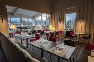 阿克1800Belambra Clubs Arc 1800 - Hôtel Du Golf的餐厅设有桌椅和窗户。