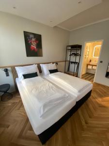 维也纳Boutique Hotel Kolbeck的卧室铺有木地板,配有一张大白色床。