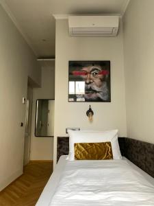 维也纳Boutique Hotel Kolbeck的卧室配有一张床,墙上挂有绘画作品