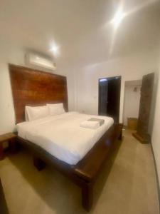 涛岛Bamboo Villa的一间卧室配有一张大床和木制床头板