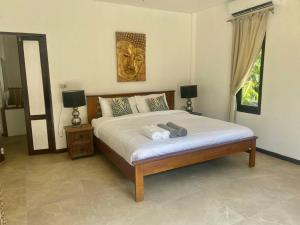 涛岛Bamboo Villa的一间卧室配有一张带两盏灯的床,墙上有一只狮子