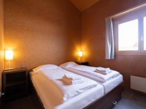UrmeinHoliday Home Komfort Aclas Maiensäss Resort-1 by Interhome的一间卧室配有一张大床和毛巾