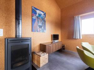 UrmeinHoliday Home Komfort Aclas Maiensäss Resort-1 by Interhome的客厅设有壁炉和电视。