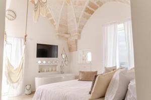 萨维勒特里Apulia Charming Suites - Casa Rossa Suite Perla e Suite Corallo的白色卧室设有1张床和1个浴缸