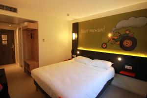 弗莱尔弗莱尔宜必思尚品酒店的卧室配有一张挂有墙上标志的床