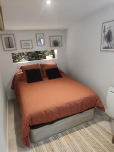 EsnandesChambre avec entrée indépendante的一间卧室配有带橙色床单和枕头的床。