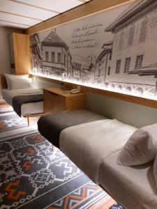 特拉夫尼克Lipa Hotel的一间设有三张床的客房,墙上挂着壁画