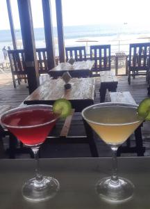 卡纳科纳Fernandes Bar and Restaurant的两张鸡尾酒坐在桌子上,享有海景