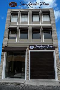 拉塔昆加Hotel San Agustin Plaza的前面有两扇车库门的建筑