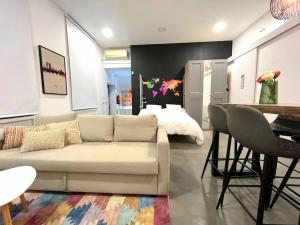 马德里Precioso estudio en Barajas, a un paso del Metro的客厅配有沙发、桌子和床。