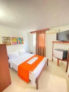 里奥阿查Hotel La Guajira的一间卧室配有一张带橙色毯子的床