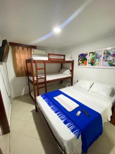 里奥阿查Hotel La Guajira的一间卧室配有一张床和一张双层床,配有蓝色毯子