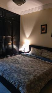 阿加迪尔Appartement au centre Agadir résidence privée的一间卧室配有一张大床和一盏灯
