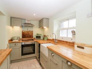 沃明斯特Granary Cottage的厨房配有木制台面和水槽