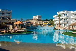 沙姆沙伊赫Palma Di Sharm Hollywood Resort的一座大型游泳池,位于拥有建筑的度假胜地