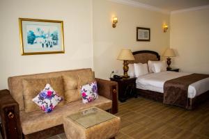 沙姆沙伊赫Palma Di Sharm Hollywood Resort的酒店客房设有一张沙发和一张床