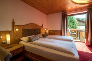 奥蒂塞伊Garni Alba Bed & Breakfast的一间卧室设有一张大床和一个大窗户