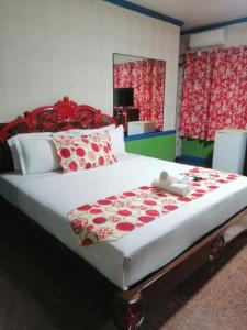 大雅台Sang Yoo Mountain View Tagaytay Bed and Breakfast - Taal Lake View的一间卧室配有一张带红色和白色枕头的大床