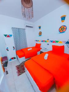 阿斯旺Lawanda Nubian House的一间卧室配有两张红色的床和吊灯。