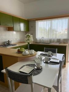 法马古斯塔Nicocreon Guest House的厨房配有桌子和白色的桌椅