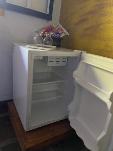 布鲁马迪纽Pousada das Brumas的空的白色冰箱,门打开