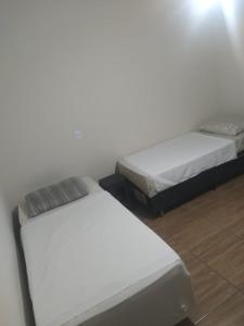 约恩维利Pousada Joinville的两张睡床彼此相邻,位于一个房间里
