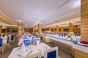 甘达坞伊港Abou Sofiane Hotel的餐厅设有白色的桌子和蓝色的椅子