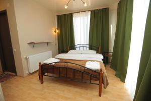 库塔伊西CHOGO的一间卧室配有一张带绿色窗帘的床