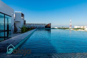 坎昆Torre Sofia magnific apartments & estudios with great amenities的建筑物屋顶上的游泳池
