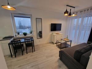 谢德尔采68 - Apartamenty Siedlce - Nowy apartament w centrum przy ul. 3 Maja 51a的客厅配有桌子和沙发