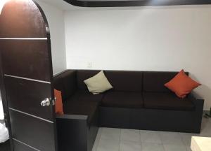 阿卡普尔科Hotel magallanes con cocineta 100 Metros de playa的一张黑色沙发,配有两个枕头