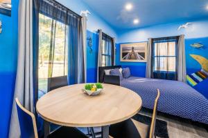 开普查尔斯Whimsical Tiny House, Cape Charles Virginia的一间蓝色的卧室,配有一张桌子和一张床