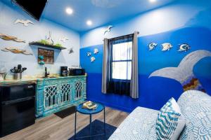 开普查尔斯Whimsical Tiny House, Cape Charles Virginia的一间拥有蓝色墙壁的客房和一间带柜台的厨房