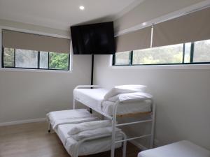 麦夸里港T's Resort & Motel的带三张双层床和两扇窗户的房间