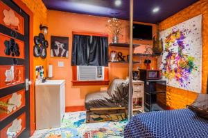 开普查尔斯Red House Tiny Home的一间卧室设有橙色的墙壁、一张床和一张书桌