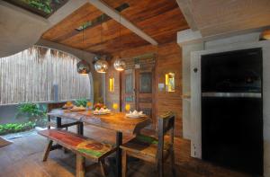 坎古Villa Tatu by Optimum Bali Villas的一间带木桌和椅子的用餐室