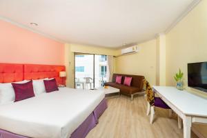 北芭堤雅贝拉维拉都市酒店的一间卧室配有一张床、一张书桌和一台电视。