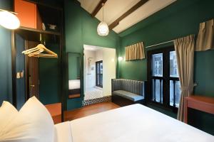 新加坡Dream Chaser Boutique Capsule Hotel的一间绿色墙壁、一张床和窗户的房间
