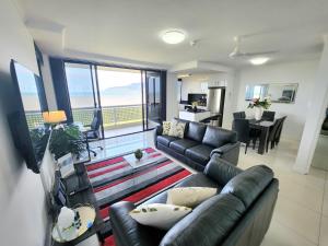 凯恩斯Cairns Luxury Seaview Apartment的带沙发的客厅和带阳台的客厅
