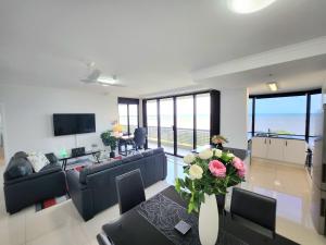 凯恩斯Cairns Luxury Seaview Apartment的客厅配有沙发和鲜花桌