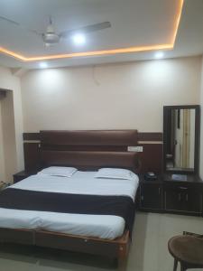 AmbikāpurHotel Anmol的一间卧室配有一张床和镜子